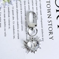 Polished silver heart pendant keychain with starburst design and lobster clasp detail - White Thorny Star Heart