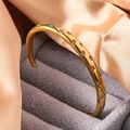 Detailweergave van goudkleurige armband met sterren en zirkoon op grijs fluweel - Goud