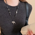 Detailed close-up of a minimalist silver horse pendant on a black and white braided rope chain - Woven Rope Stone Bead Horse Necklace