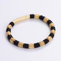 Gros plan détaillé du bracelet en cuir tressé avec perles dorées et fermoir magnétique - Or Motif de Grille