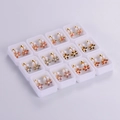Detailed top view of 12 pairs of colorful flower stud earrings in white boxes - Cherry Blossom Style (12 Pairs)