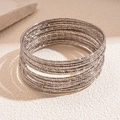 Detail shot of multi-layered silver metal bangles with textured faceted surface finish - Silver (Set of 20)