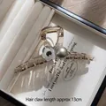 Detalle de pinza para el cabello de 13cm color ámbar con adornos de flor y perla - Pinza de perlas con flores gris ceniza grandes