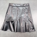 Detailed view of black PU leather mini skirt featuring decorative buttons and ruffled hemline - S / Black
