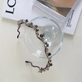 Sparkling dark gray crystal beaded headband with light purple fabric base on a glass - Wave Grey Beads