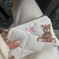 Nahaufnahme der cremefarbenen Stepp-Kosmetiktasche mit Teddybär-Print und rosa Schleife - 15*10cm / Beigefarbener Teddybär