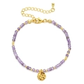 Close-up of purple stone beaded bracelet with gold accents and hammered metal pendant - Purple