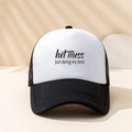 Detail van de tekstprint op een zwart-witte truckercap met mesh en slogan-opdruk - Zwart