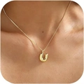 Golden necklace with letter U pendant on a model's neckline in detailed close-up shot - Gold U