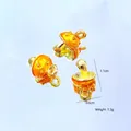 Macro detail of miniature mushroom charms with orange enamel finish and gold plating - Yellow Mushroom