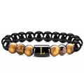 Détail d'un bracelet en œil de tigre avec une perle noire et la lettre L dorée - Lettre L