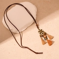 Detail view of ethnic long necklace featuring floral metal parts and colorful tassels - Coffee Color Flower Style