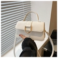 Close-up of white PU leather bag featuring a gold D-buckle and elegant top handle - White