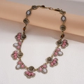 Close-up of vintage gold necklace with pink resin stones and crystal floral details - Necklace-Pink
