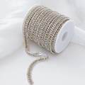 Three-row rhinestone claw chain with alternating gold and silver crystals on a white spool - 1 Yard/Pack / Silver Base White+Champagne