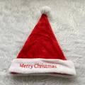 Detail of red plush Santa hat featuring white embroidered Merry Christmas text - Red Embroidery Style