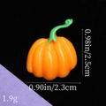 Vista macro di un ciondolo a forma di zucca in resina per fai-da-te con misure incluse - Zucca con Vite Verde - Arancione Brillante