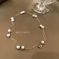 Double-layered gold chain necklace with white baroque pearls and a lobster clasp - Faux Pearl Necklace