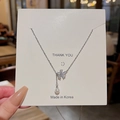 Detailed shot of a silver floral pendant with a pearl held on a white display card - Silver (Five-petal Flower Pearl)