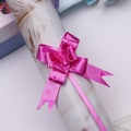 Detail of bright pink pull bow with heart print pattern on a white paper reel - Rose Red Heart