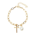 Dettaglio del bracciale dorato con catena a graffetta, ciondolo a croce e perla - Bracciale Perla Croce Oro / Stile Croce