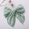 Detail of mint green embroidered cotton bow hair clip with intricate floral cutout patterns - Bean Green