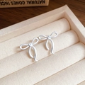 Elegant matte white bow earrings with silver needles presented in a luxury jewelry box - 925 Silver Needle / White