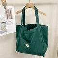 Detalle del bolso tote de lona verde con rayas de contraste y bolsillo frontal exterior - Verde hierba
