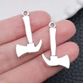 Silver metal axe-shaped pendants shown on fingertips for size scale and detail - Axe / 16x26mm 1.6g