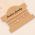 Boho-Armband-Set mit rosa Natursteinen und geflochtenem Seil auf einer Schmuckkarte - Rosenquarz