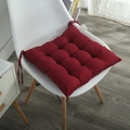 Detalle de cojín de silla rojo acolchado con cintas sobre una silla blanca moderna - Burdeos