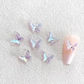 Macro shot of 3D iridescent resin butterfly charms for nail art on white background - Aurora Purple