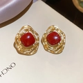 Vue macro de boucles d'oreilles géométriques dorées avec pierre rouge et fond en soie - 80# Tige en Argent-Or-Rouge