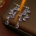 Detail of silver drop earrings with purple gemstones on a jewelry box display - Silver Purple Multi Round Diamond Tassel Style