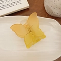 Translucent yellow butterfly hair claw clip with a matte finish on a ceramic plate - Yellow Gradient Butterfly Claw Clip / Yellow Gradient