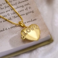 Collana con medaglione a cuore vintage dorato e scritta LOVE su sfondo di libri - Stile con Lettera LOVE