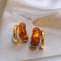Vue macro des boucles d'oreilles double C dorées avec résine ambre sur soie - Style Créole en Résine (2#) / Brun doré