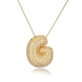 Golden seashell pendant necklace with crystal pavé and thin box chain on white background - Letter G