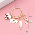 Detail showing 30mm diameter and 60mm length of the medical theme enamel keychain - White EKG Heart Keychain Gold Color
