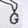 Dettaglio della collana con ciondolo lettera G nero opaco con bordi ondulati su sfondo bianco - Lettera G (Nero Con Catena)