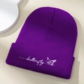 Gros plan détaillé de la broderie papillon sur le rebord d'un bonnet en maille violet - Taille unique / Violet foncé