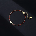 Close-up of gold-plated stainless steel cross bracelet with red enamel beads and clasp - Gold-Red