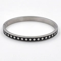 Detail view of a black enamel titanium steel bangle with silver polka dot patterns - Steel Black
