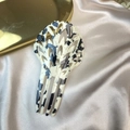 Detail of fan-shaped acetate hair comb with black and white spots on silk background - Black and White