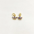 Close-up of golden crown pendants with purple zircon stones on white background - Purple Zirconia
