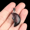 Carved moon face pendant in red and black natural stone with silver bail accessory - Rhodonite