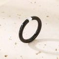 Nahaufnahme eines schwarzen Hochglanzrings mit rundem Zirkon auf hellem Steinuntergrund - US 6 / Dünner Einzelstein (3mm) / Schwarz mit Stein (KR44314-K)