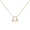 Macro view of gold Libra zodiac pendant featuring sparkling zircon stone settings - Gold Libra