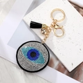 Macro detail of Evil Eye keychain with sparkling rhinestones, gold hardware, and black tassel - Black Pointy Eye Gold Clasp