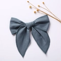 Detailed texture of blue-grey cotton linen bow hair clip on a clean white background - Blue Gray